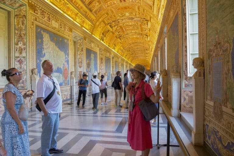 Gallery of maps inside the Vatican Museums with tour guide leading group