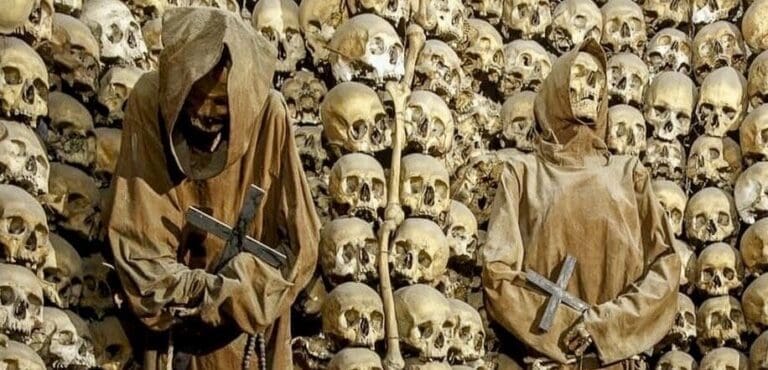 Capuchin Crypt in Rome showing the skeletons of two robed friars in niches made from human skulls