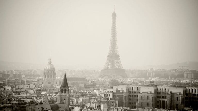 Black and white photo of Paris on a foggy day with the Eiffel Tower in the distance