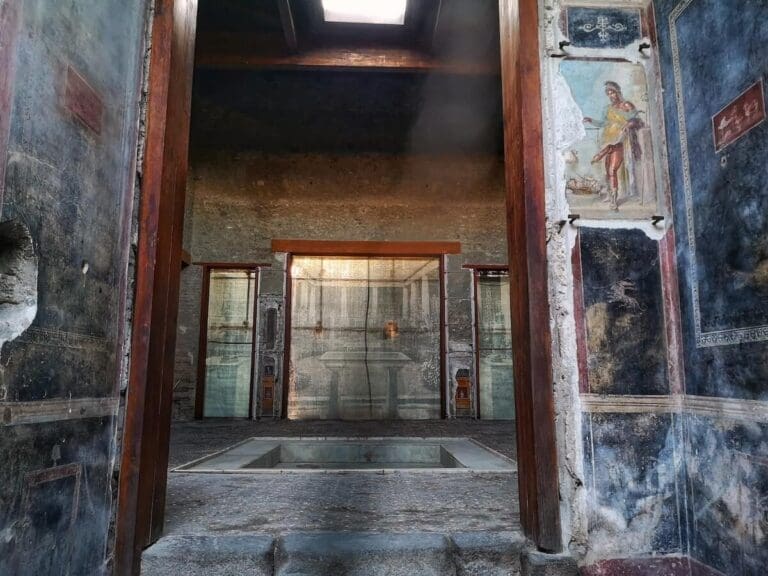 House of the Vetti Pompeii, a view from the entrance into the atrium with a fresco showing the god Priapus on the wall