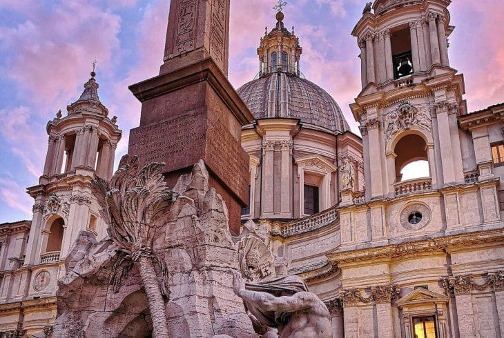 Piazza Naovona at Sunset in Rome showing the Fountain of the Four Rivers by bernini and the church of saint agnes in agone in the background