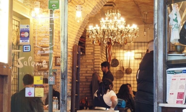 View into the Pane e Salame sandwich shop with exposed brick walls and chandeliers visible