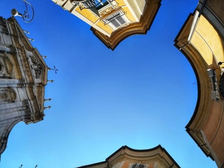 view into the sky of the piazza in front of sant' Ignazio with the top of the church and surrounding buildings visible