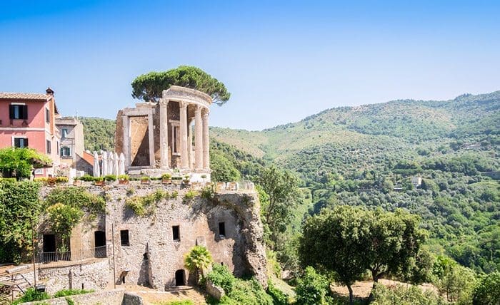 View of the Temple of Vesta in the villa Gregoriana with the rolling hills of Tivoli in the background