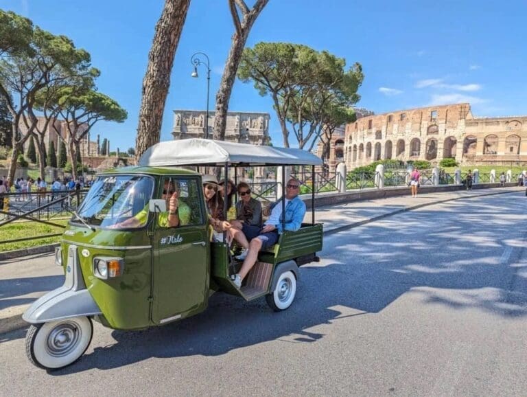 Family enjoying a Piaggo tour heading past the Colosseum