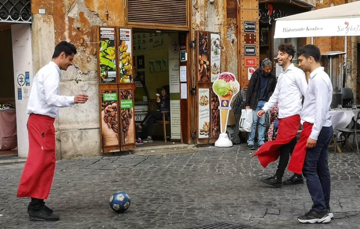 waiters play football outside Ristorante Kosher